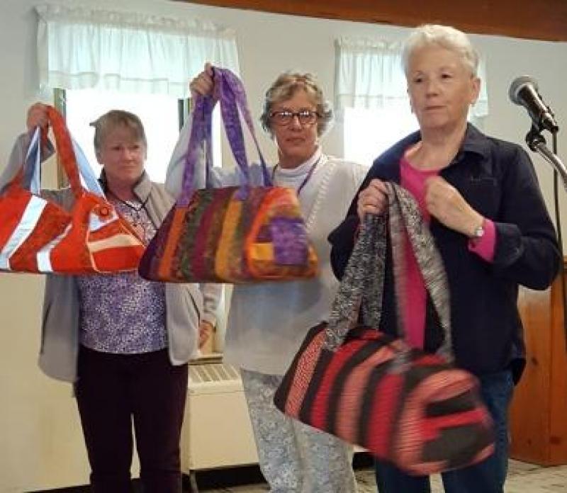Teacher for last months class, Tina G, and 2 of the participants, Carol L and Peggy F, show us their completed duffel bags